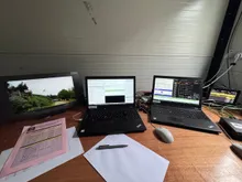 A timing desk with laptops, start lists and a live camera feed