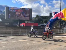 Riders on course in front of the big screen at a Red Bull motocross event